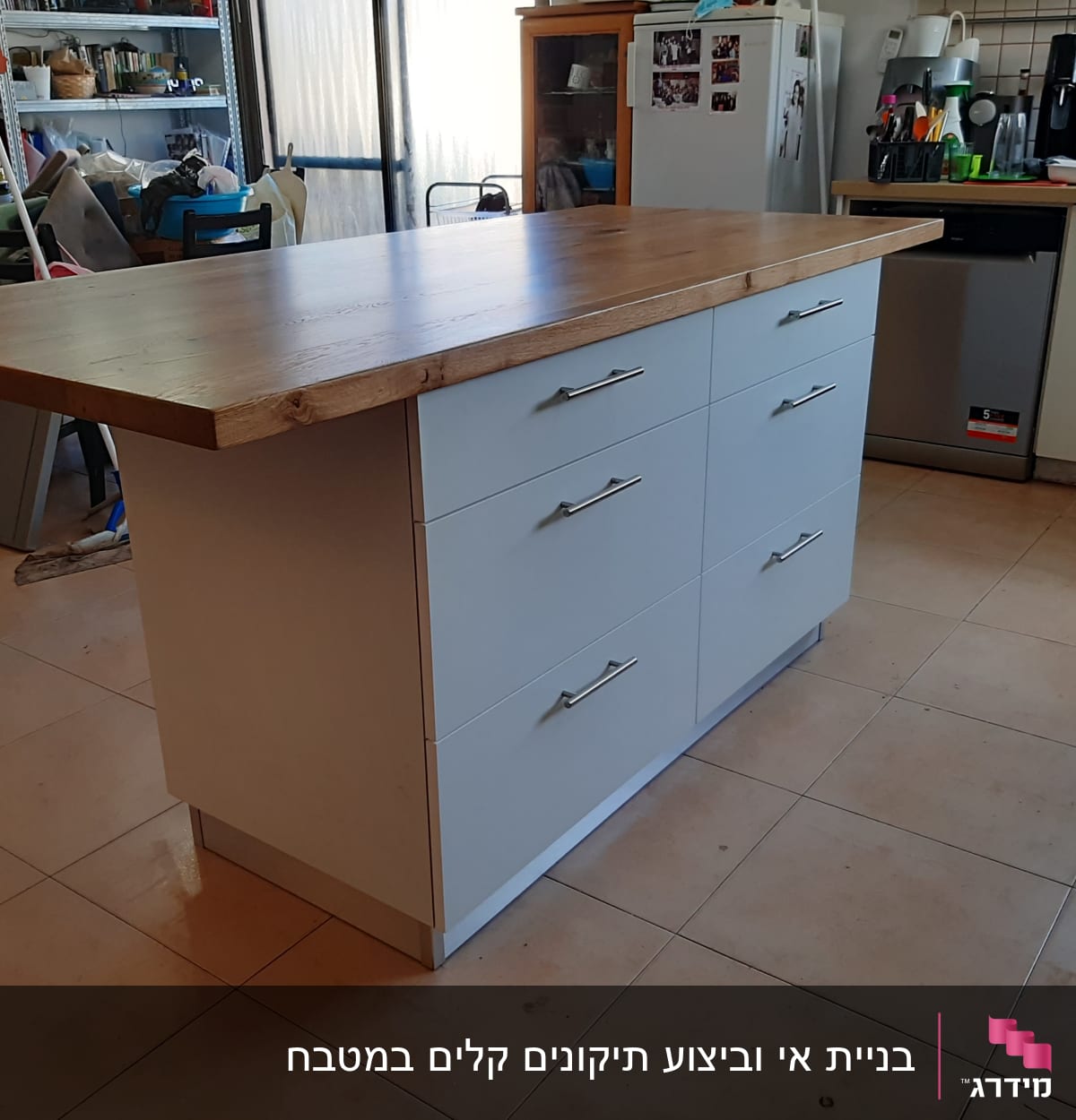 אי מטבח עם משטח עץ ומגירות לבנות